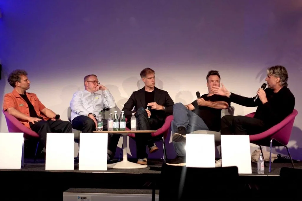 Five panelists in armchairs on stage at SoundTrack_Zurich discussing production music and AI